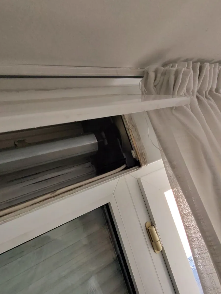 Mecanismo de persiana en el marco de una ventana